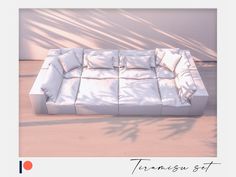 a white couch sitting on top of a wooden floor next to a wall with shadows