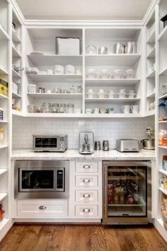 a kitchen with white cabinets and open shelving