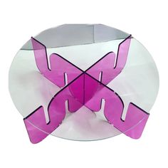 a glass plate that has some kind of pink object on it's side and is shaped like an x