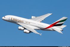 an emirates airplane flying in the sky with its landing gear down and it's tail extended