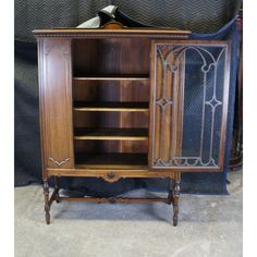 an old fashioned wooden cabinet with glass doors