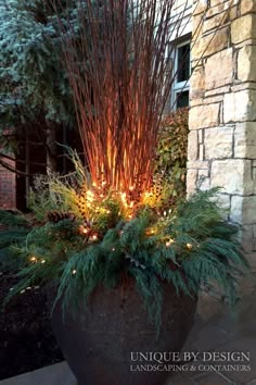 a planter with lights in it sitting next to a brick wall and stone building