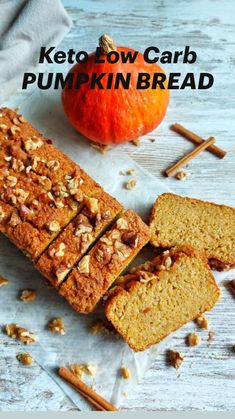 sliced loaf of pumpkin bread next to an orange and cinnamon stick on a white wooden table