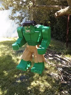 a green and brown paper mache standing in the grass