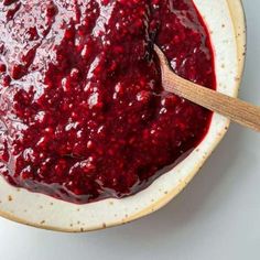 a bowl filled with cranberry sauce and a wooden spoon