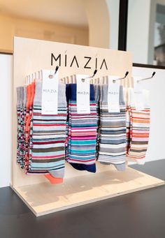 several pairs of colorful socks are on display in a store with price tags hanging from them