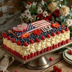 an american flag cake with strawberries and blueberries on the bottom is sitting on a platter