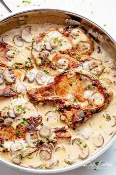 a pan filled with chicken and mushrooms covered in gravy on top of a table