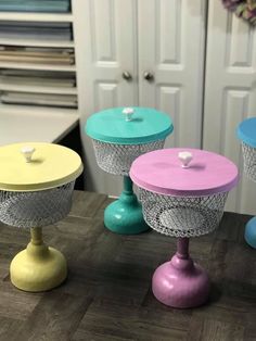 three different colored vases sitting on top of a wooden table