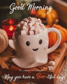 a white mug filled with marshmallows sitting on top of a wooden tray