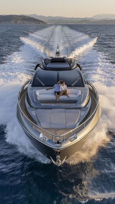 two people are sitting on the back of a boat