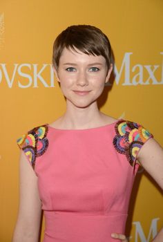 a woman in a pink dress posing for the camera