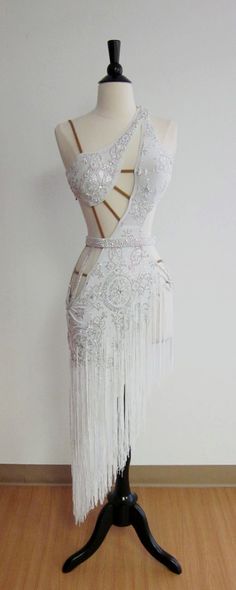 a mannequin dressed in white with fringes on it