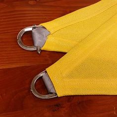 a pair of metal scissors on top of a piece of yellow fabric with holes in it