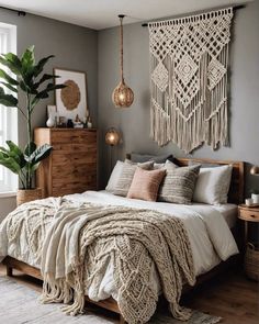 a bedroom with grey walls and white bedding, wooden dressers and hanging plants