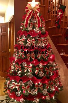 a christmas tree decorated with red ribbon and bows