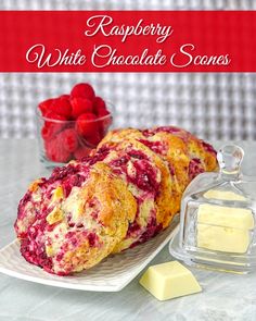 raspberry white chocolate scones on a plate with butter and strawberries in the background