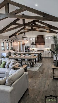 a living room filled with furniture and a large kitchen in the back drop down ceiling