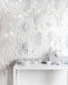 a white table topped with lots of balloons and confetti on top of it