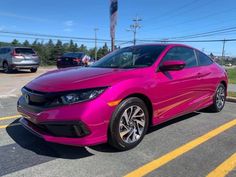 a pink car parked in a parking lot