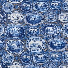 blue and white plates are arranged on a tablecloth with an intricate design in the center