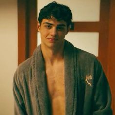 a shirtless young man wearing a robe