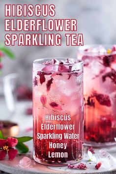 hibiscus elderflower sparkling tea on a tray with pink flowers and ice in the background