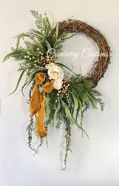 a close up of a wreath with flowers and greenery on the front of it