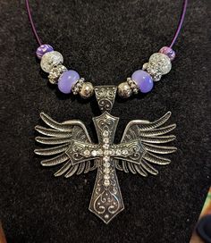 Beautiful cross with wings, has purple, clear, and silver accent beads, this is a choker style necklace to show off this beautiful cross for that eye catching effect. this will go great with any outfit and for every occasion. Great gift ideas. Silver Cross Jewelry With Beads, Adjustable Purple Jewelry With Silver Beads, Silver Spiritual Cross Beaded Necklace, Spiritual Silver Cross Beaded Necklace, Silver Cross Beaded Necklace For Spiritual Style, Purple Jewelry With Silver Round Beads, Silver Beaded Necklaces With Bling For Gifts, Adjustable Purple Rhinestone Jewelry, Cross With Wings