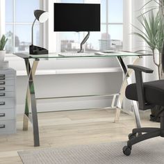 an office chair sits in front of a desk with a monitor and keyboard on it