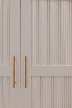 two white doors with gold handles on them