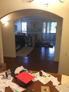 a living room filled with lots of clutter on top of a hard wood floor