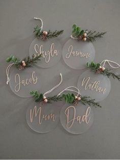 six personalized acrylic christmas ornaments with pine cones and greenery on them