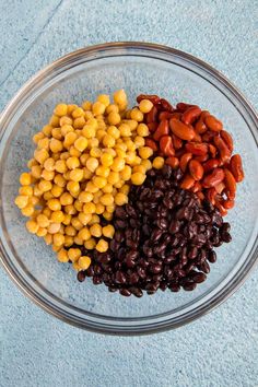 beans, corn and carrots in a glass bowl on a blue towel top view