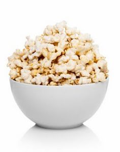 a white bowl filled with popcorn sitting on top of a table