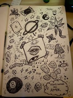 an open notebook with drawings on it and various symbols around the page, including eyeballs