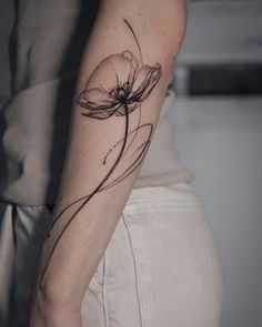 a woman's arm with a flower tattoo on the left side of her arm