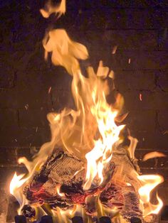 a fire burning in a fireplace with lots of flames