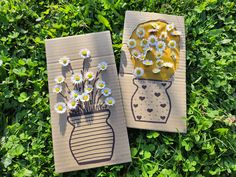 two handmade cards with flowers in vases on top of green leaves and grass