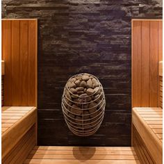 there is a basket full of rocks in the middle of a sauna room with wooden benches