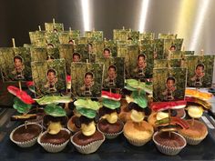 cupcakes with pictures of people on them are displayed in front of the camera