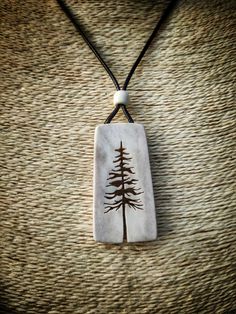 a pendant with a tree on it sitting on top of a woven tablecloth covered surface