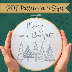 two hands holding up a cross - stitch christmas tree with merry and bright written on it