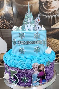 a frozen princess themed cake with cupcakes and frosting on the top is for someone's 5th birthday