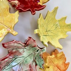 four leaf shaped dishes sitting on top of a white countertop next to each other