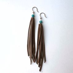 Add a touch of bohemian flair to your outfit with these unique handmade leather tassel earrings.  Accented with stunning turquoise beads, and white seed beads, these earrings are a one-of-a-kind addition to your jewelry collection. Perfect for everyday wear or special occasions, these earrings are sure to make a statement wherever you go. Turquoise Tassel Earrings With Dangling Beads For Gifts, Southwestern Tassel Earrings, Bohemian Turquoise Tassel Earrings, Bohemian Turquoise Leather Earrings, Bohemian Turquoise Hand-tooled Earrings, Turquoise Leather, Leather Tassel, Copper Earrings, Turquoise Beads