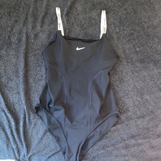 Black Nike Bodysuit. Never Worn !! Soft Stretchy Material. Size Large. Says Nike On The Shoulder Straps Nike Bodysuit, Tops Black, Black Nike, Nike Black, Nike Tops, Women's Nike, Stretchy Material, Black Nikes, Shoulder Straps