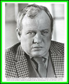 a black and white photo of a man in a suit with a green border around his neck