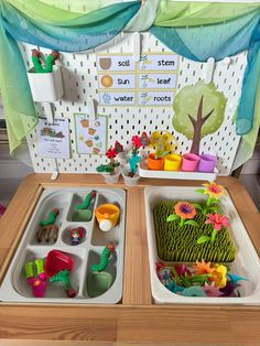 two trays filled with food on top of a wooden table in front of a bulletin board