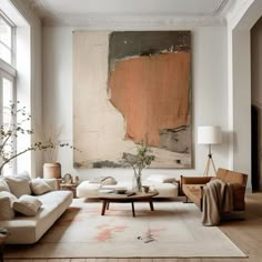 a living room filled with furniture and a large painting hanging on the wall above it